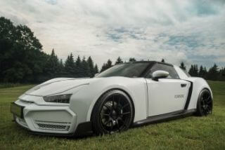 Sleek white sports car viewed from a 3/4 angle on a grass field